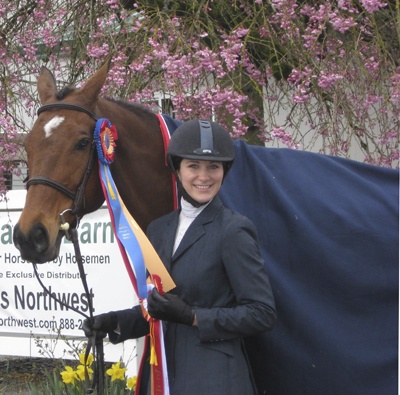 Jami Balint shows the championship ribbon she won with Moment In Time from the June 17-20 Early Summer Classic Hunter/Jumper horse show in Wilsonville