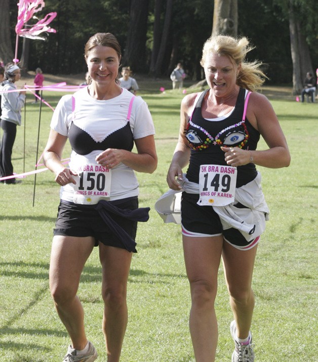 A pair of women cross the finish line together in the Wings of Karen 5K Bra Dash at Lake Wilderness Park Sept. 9. The event raised $30