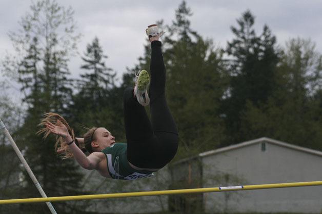 A Kentwood girl pole vaulter attempting to land on the other side of the bar.
