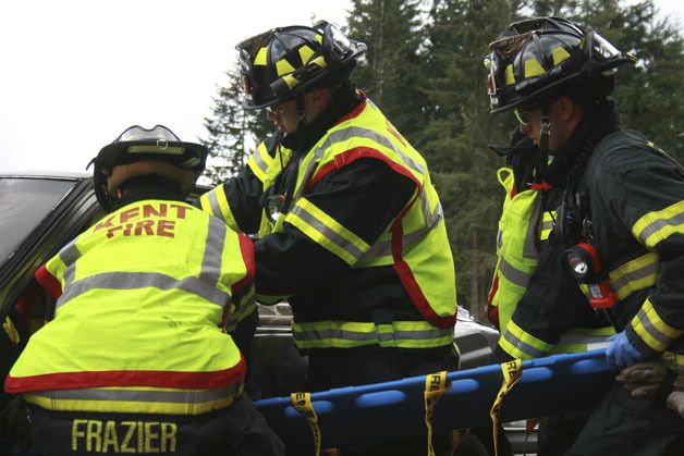 Firefighters from the Kent Fire Authority participate in a mock car crash at Tahoma High on Friday