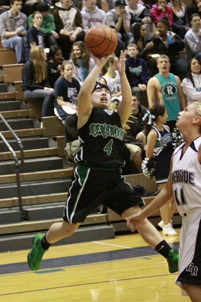Kentwood’s Kylie Huerta takes a shot as Auburn Riverside’s Brooklyn Hinkens looks on in a game Tuesday night.
