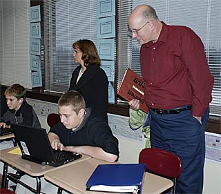 Tahoma School Board member Bill Clausmeyer looks over seventh grader Brian Karlsson’s shoulder during the board’s stop at Tahoma Middle School.