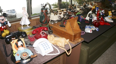 Keith Deaver has collected phones since 1949 and has more than 100 working telephones in his Black Diamond home. His phone collection includes antiques and novelty phones like the Marilyn Monroe phone in the photograph.