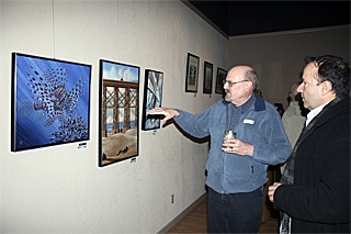 Douglas Williams describes his painting to James Kelley at the Creative Arts Council gallery opening Friday evening.