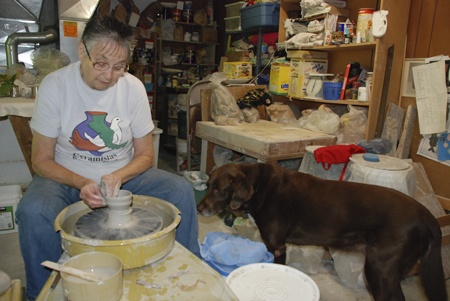 Elinor Maroney demonstrates how she makes ceramics on her pottery wheel at her in-home studio near Covington while her dog Maggie