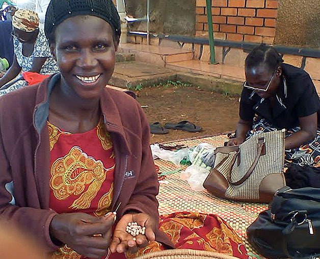 A Ugandan woman shows off handmade beads used in the bracelet which will be sold to raise money for Wings of Karen and African Promise Foundation.