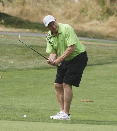 Kent Fire Chief Jim Schneider checks out the distance to the hole during the Covington Chamber of Commerce Golf Tournament Friday