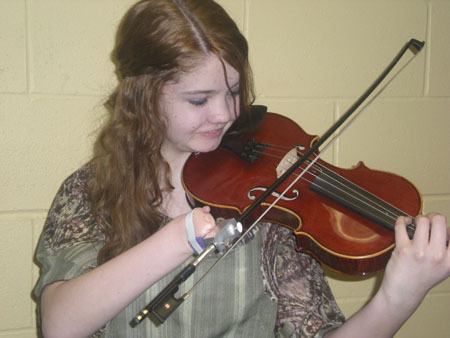 Abigail Brown of Maple Valley demonstrates how she plays the violin with the aid of a device attached to the bow.