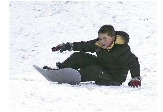 Jacob Stone finishes his ride down a snowy hill on his posterior at Lake Wilderness Golf Course in Maple Valley Dec. 19.