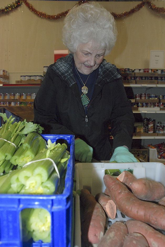 Joan McIntyre chops celery Tuesday morning at the Maple Valley Food Bank prior to its opening to clients to select food. McIntyre has volunteered with the food bank for 12 years. Clients can select food three days a week.