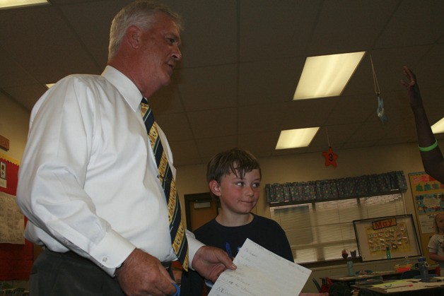 Crestwood Principal Thomas Shearer receives a welcome letter from a student while second grader Carter Ingram looks on.  Shearer was originally appointed as interim principal before being hired permanent in the late spring.