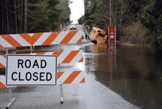 A Tahoma School District bus is stuck after the substitute driver decided to drive past the 'Road Closed' signs. Water on the road hid a break in the pavement. Students on the bus were not injured. The bus was en route to the Covington Aquatic Center taking the students to swim team practice.