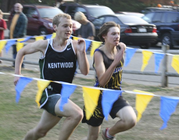 A Kentwood and Tahoma runner attempt to beat the other to the finish line during the junior varisty race.