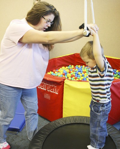 A therapist works with an autistic child at the Good Samaritan Children’s Therapy Unit in Puyallup.
