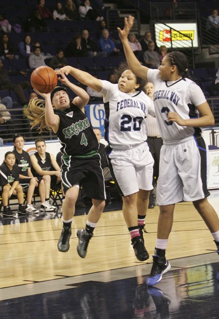 Kentwood point guard Kylie Huerta takes a shot over a pair of Federal Way defenders during a playoff game last season.