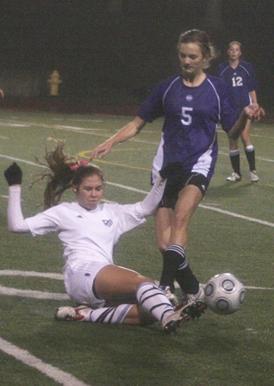 Lauren Duty for Tahoma slides and kicks the ball away from Hannah Huesers for Lake Stevens Saturday at home in the second round of the quarterfinals of the 4A girls state soccer championship. Tahoma won 2-0.