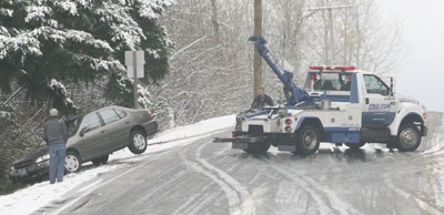 A car being towed after sliding into the ditch on Witte Road Southeast in Maple Valley Monday.