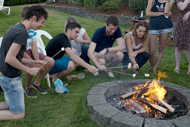 French students roast marshmallows during an evening near a lake in Black Diamond. The students are halfway through their US trip that was organized through Compass USA.