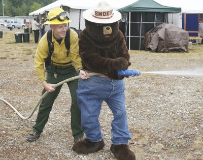 Nick Traweek from the Department of Natural Resources and Smokey the Bear work the hose at Western Washington Family Forest Owners Field Day July 31.