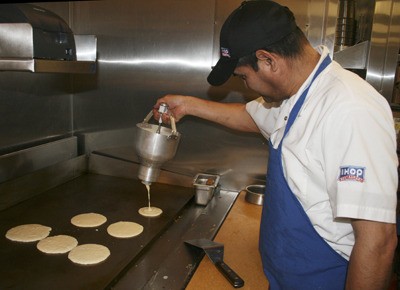 Leonardo Vergara pours pancake batter on the flat top griddle at the newly opened International House of Pancakes in Covington. It is located in the Covington Esplanade shopping center.