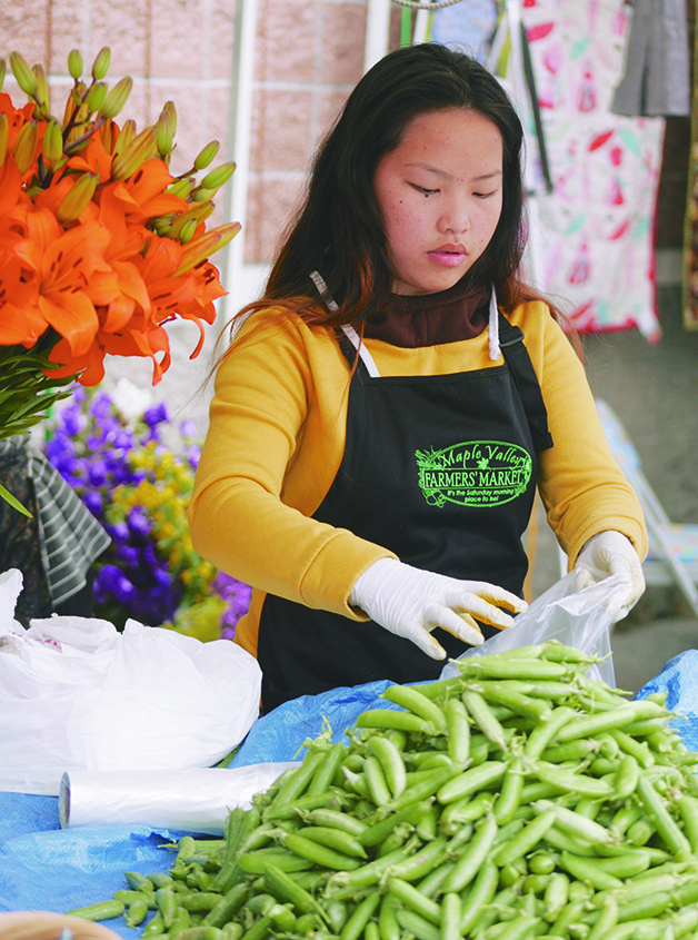 Kouchai Xiong prepares peas at the Thong Chang Garden booth Saturday