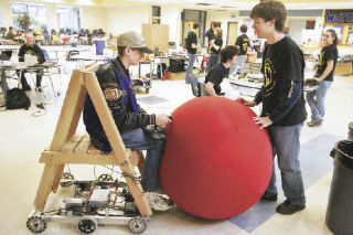 Andrew Kerr (left) drives a robot into a ball blocked by fellow Tahoma High School senior Ryan Cahoon during a flea market last Saturday at the school. The event was a fund-raiser for students’ organizations