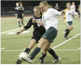 Auburn’s Ali Lundberg (right) battles for the ball with Kentwood’s Reilly Retz (left) on Tuesday in a South Puget Sound League North Division game at Auburn Memorial Stadium. Kentwood pulled out a 2-0 win to remain in first place.