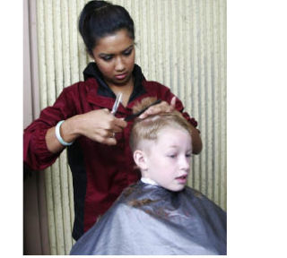 Casie Coltes gives Tyler Richardson one of the free haircuts that were offered during Kids Day America