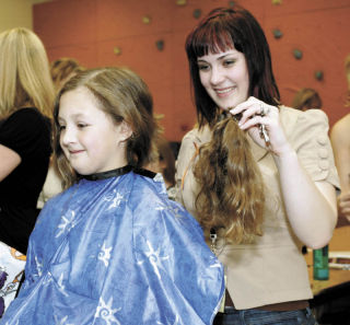 Jessee Ray-Foltz holds 10 inches of Lily Fuentes’ hair after cutting it from the fourth-grader for a Wigs for Kids benefit May 9 at Black Diamond Elementary School. Ray-Foltz