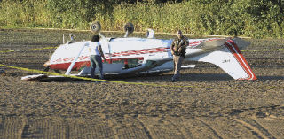 A single-engine aircraft rests on its top in an open field near Green Valley Road where it flipped over during an emergency landing Monday. The plane was en route to Auburn from Oregon when it experienced engine trouble. Its occupants