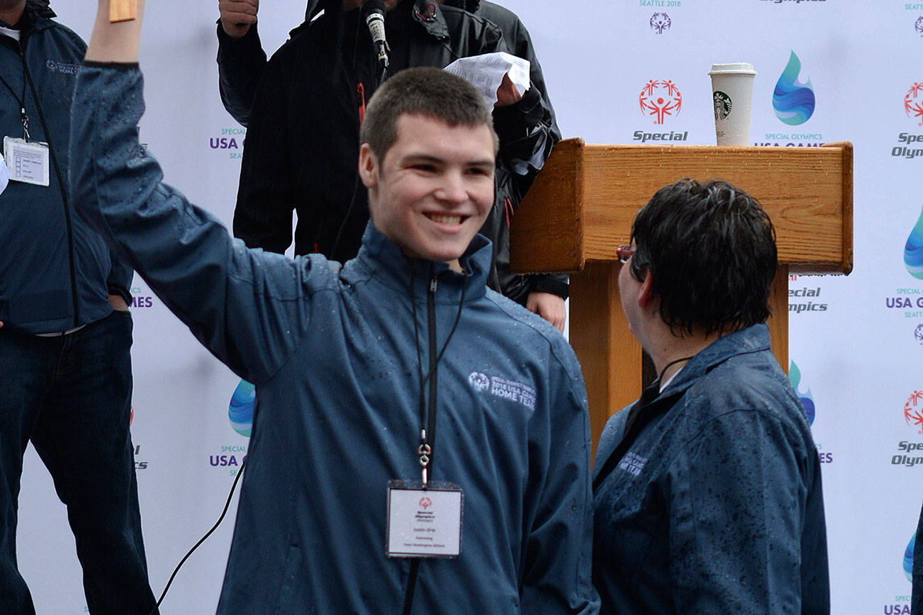 Justin Olds holds up the swimming sign proudly during the 2018 Special Olympics Home Team Announcement in Seattle on Jan. 11. Photo by Kayse Angel