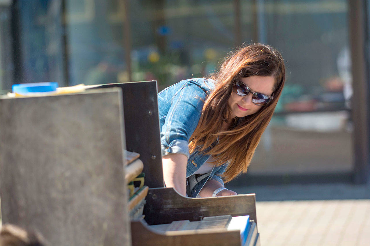 Piano artist Natalie Martin of Sequim sands down the piano that filled the Port Angeles downtown streets with music last year during a work party Saturday. (Jesse Major/Peninsula Daily News)