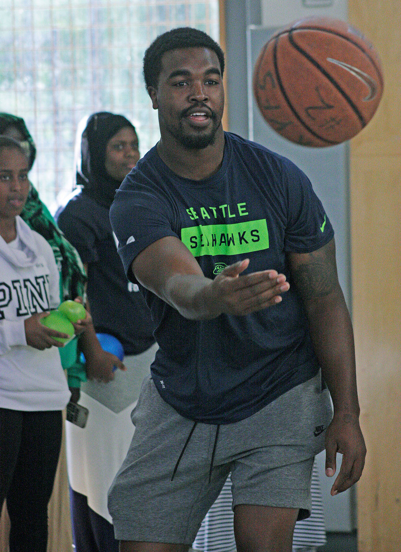 The Seahawks’ Tyrone Swoopes, a 6-foot-4 tight end, plays basketball with boys and girls during a career fair at the Birch Creek Youth Center. MARK KLAAS, Kent Reporter