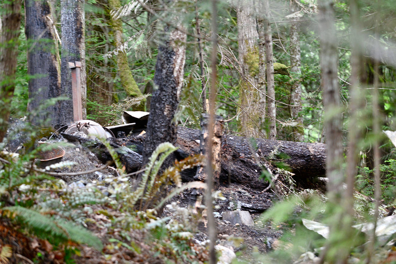 The remains of the cabin that burned Sunday morning, leaving a family of five dead. (Jesse Major/Peninsula Daily News)