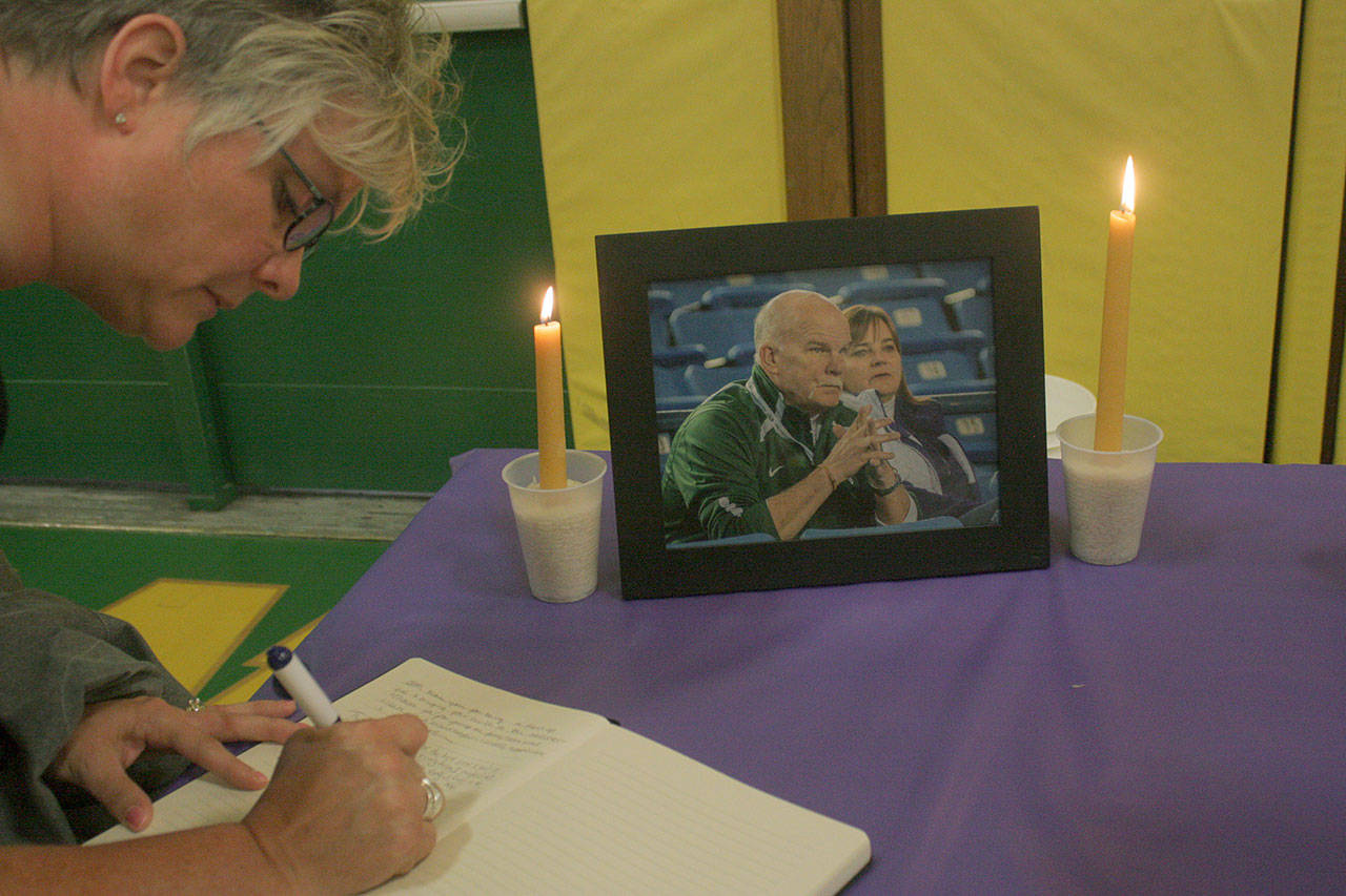 Mark Klaas, Kent Reporter                                Carrie Lantz signs a memorial book before the start of a candlelight vigil.