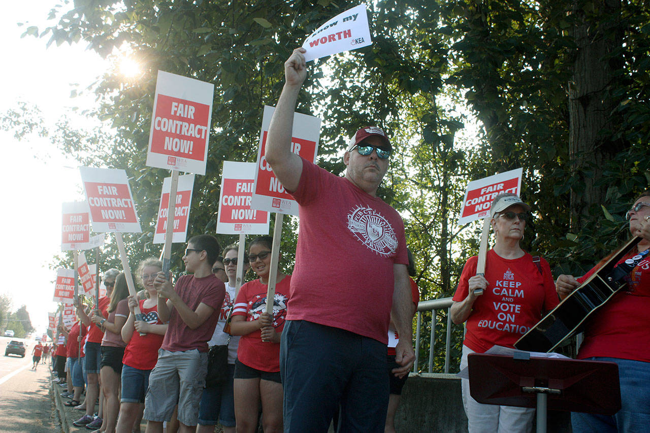 Larry Delaney, a Washington Education Association board director, joins Kent teachers for a rally outside the Kent School District headquarters Thursday morning. Hundreds of teachers lined Southeast 256th Street, chanting for better pay. MARK KLAAS, Kent Reporter