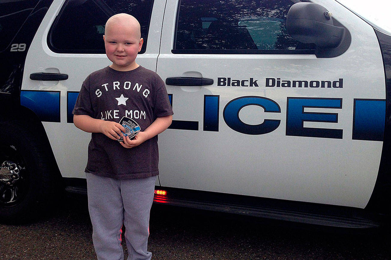 Jack Reich in front of a Black Diamond police car. Submitted photo by Brian Lynch