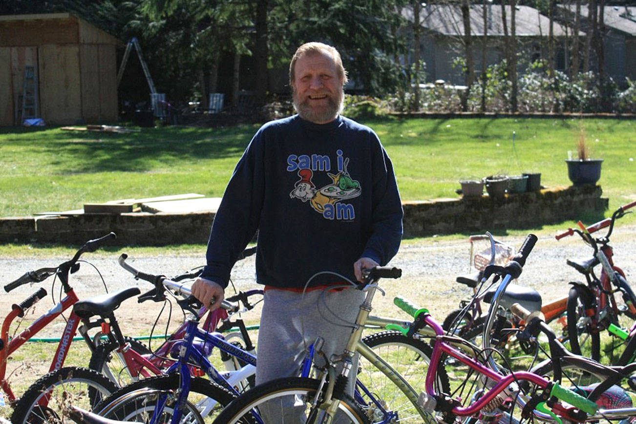 Brad Belcher, founder of Bicycle Rescue for Youth, stands surrounded by some of the bikes he has or is going to work on restoring for kids in need.