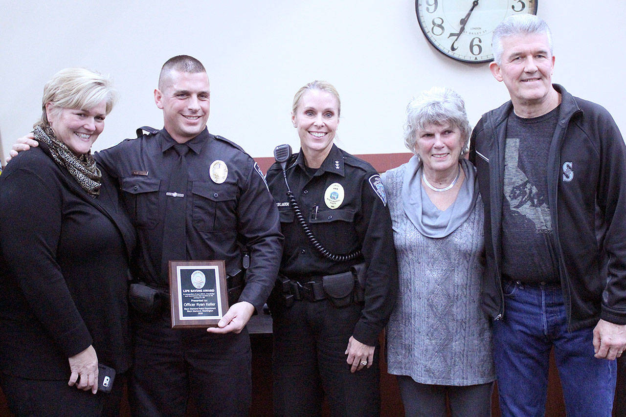 Photo by Ray Still                                From left to right, Teri Moore, Officer Ryan Keller, Police Chief Jamey Kiblinger, Mayor Carol Benson, and Joe Moore after Keller was given the Life Saving Award.