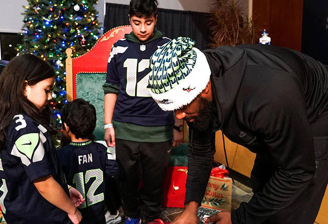 George Fant is seen giving gifts to family members during the Monday event. Photo courtesy Seattle Seahawks