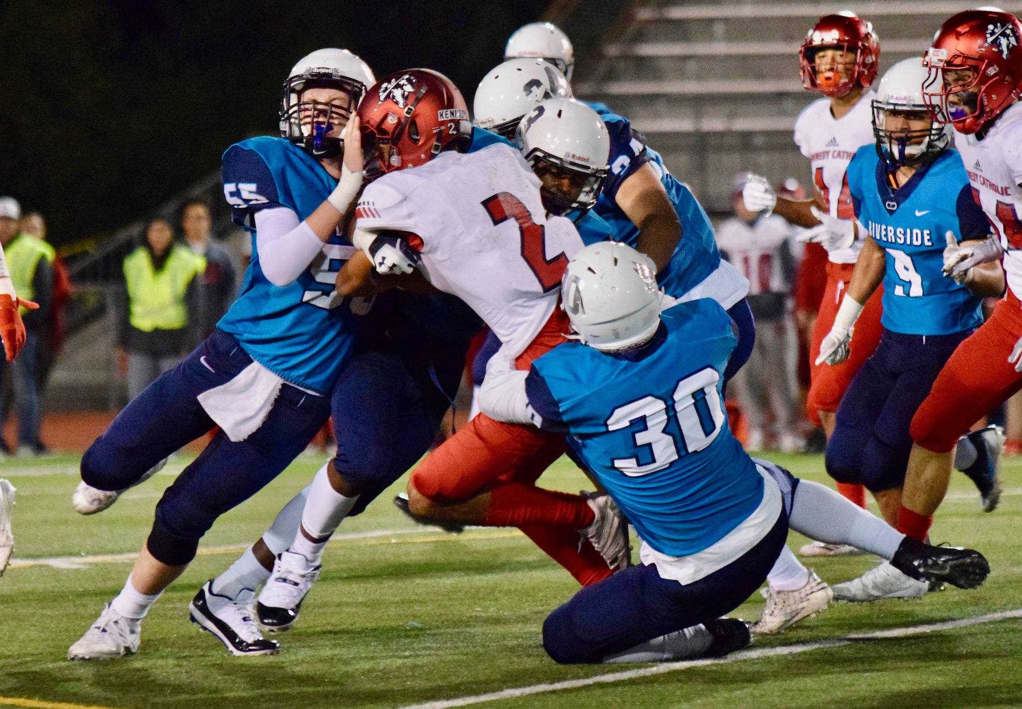 Auburn Riverside defenders bring down Kennedy Catholic’s Junior Alexander during North Puget Sound League Mountain Division action in Oct. 2018 at Auburn Memorial Stadium. Photo by Rachel Ciampi/Auburn Reporter