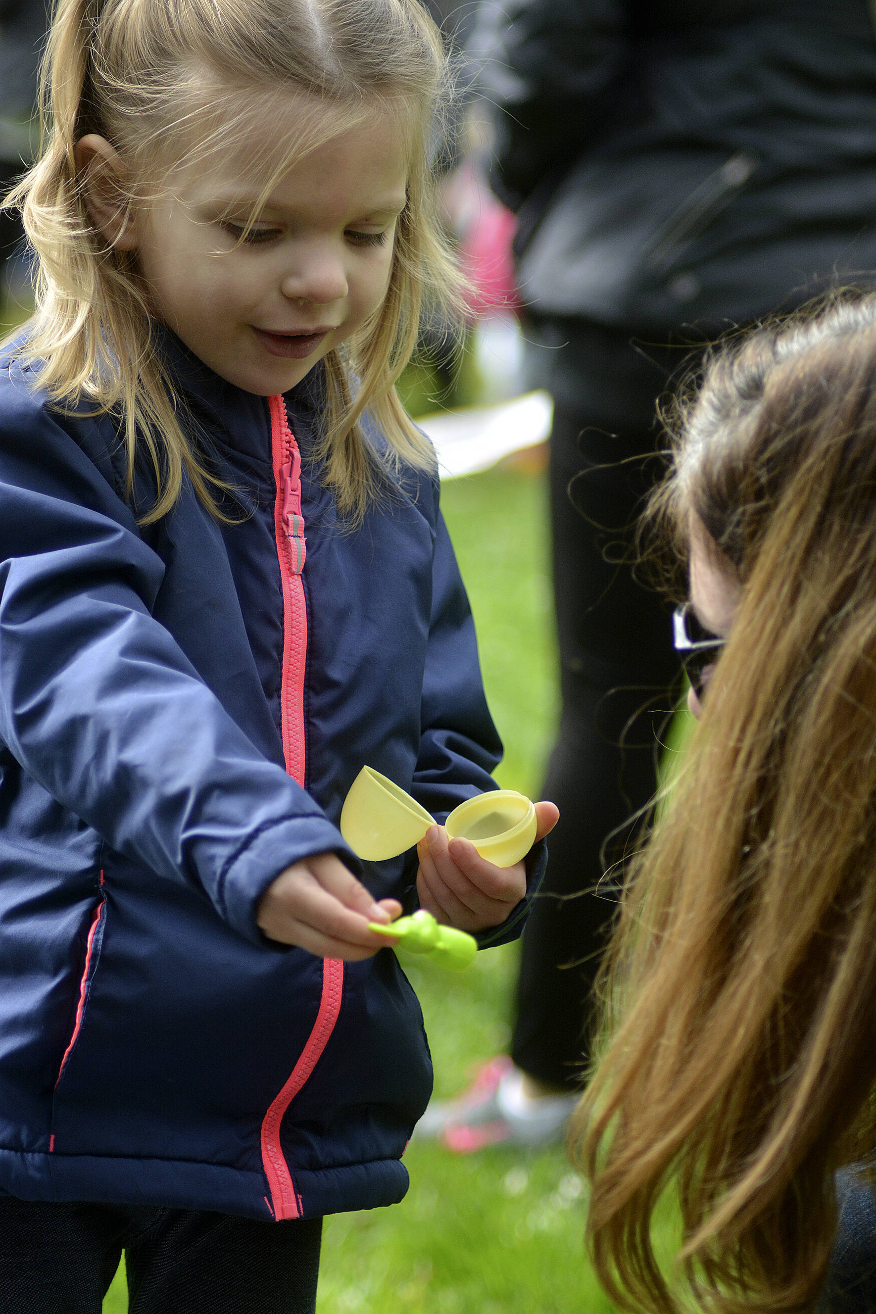 Alice Kurtz shows her family what she found in her Easter eggs at the Lake Wilderness Easter Egg hunt. Photo by Kayse Angel