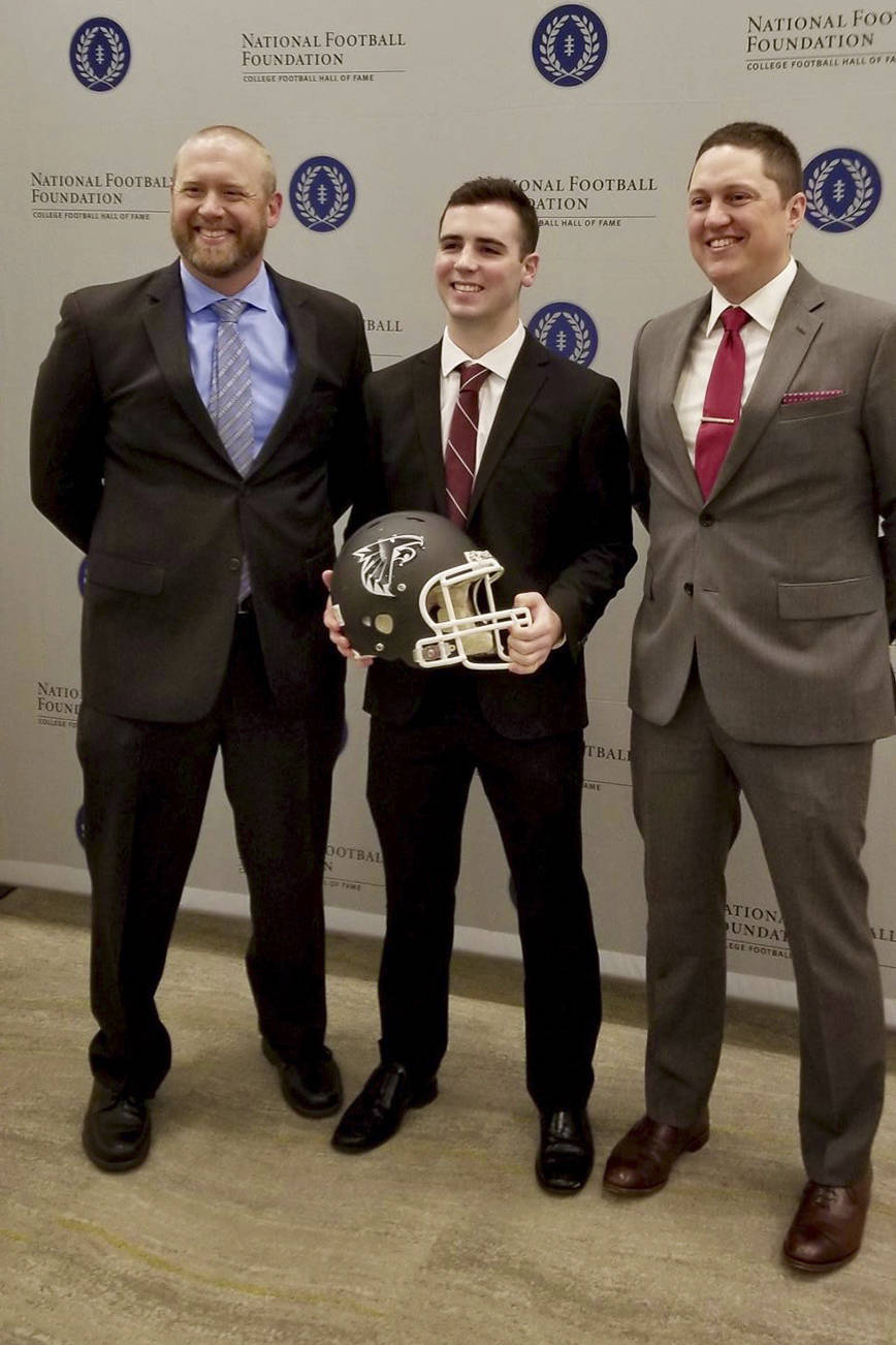 Hudson Potts receives his award with his coaches, Brett Thompson, left, and Kevin Hurt. COURTESY PHOTO