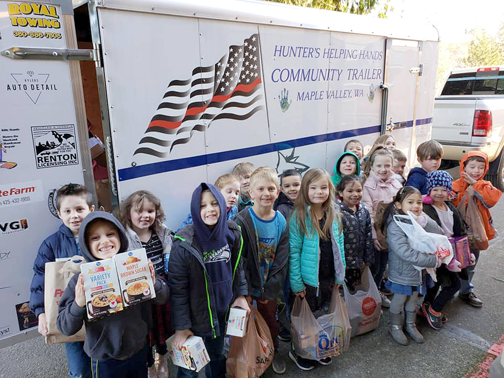 Students from Lake Wilderness Elementary School show off donated food bags they gave to Backpack Buddies for Kids. The Maple Valley nonprofit gives students with food insecurity meals for the weekend and now for the summer.                                Photo courtesy of Backpack Buddies for Kids of Maple Valley.