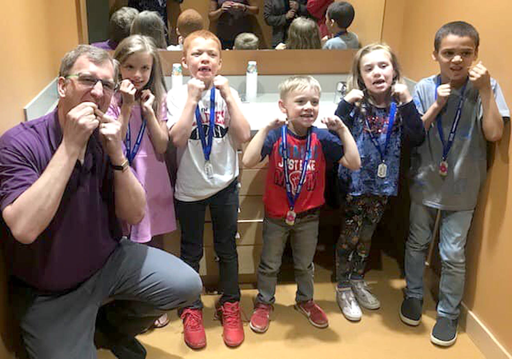 A local Covington dentist teaches kids how to floss their teeth to earn a “brag badge” in the Covington Play Unplugged challenge. Photo courtesy of the Covington Chamber of Commerce.