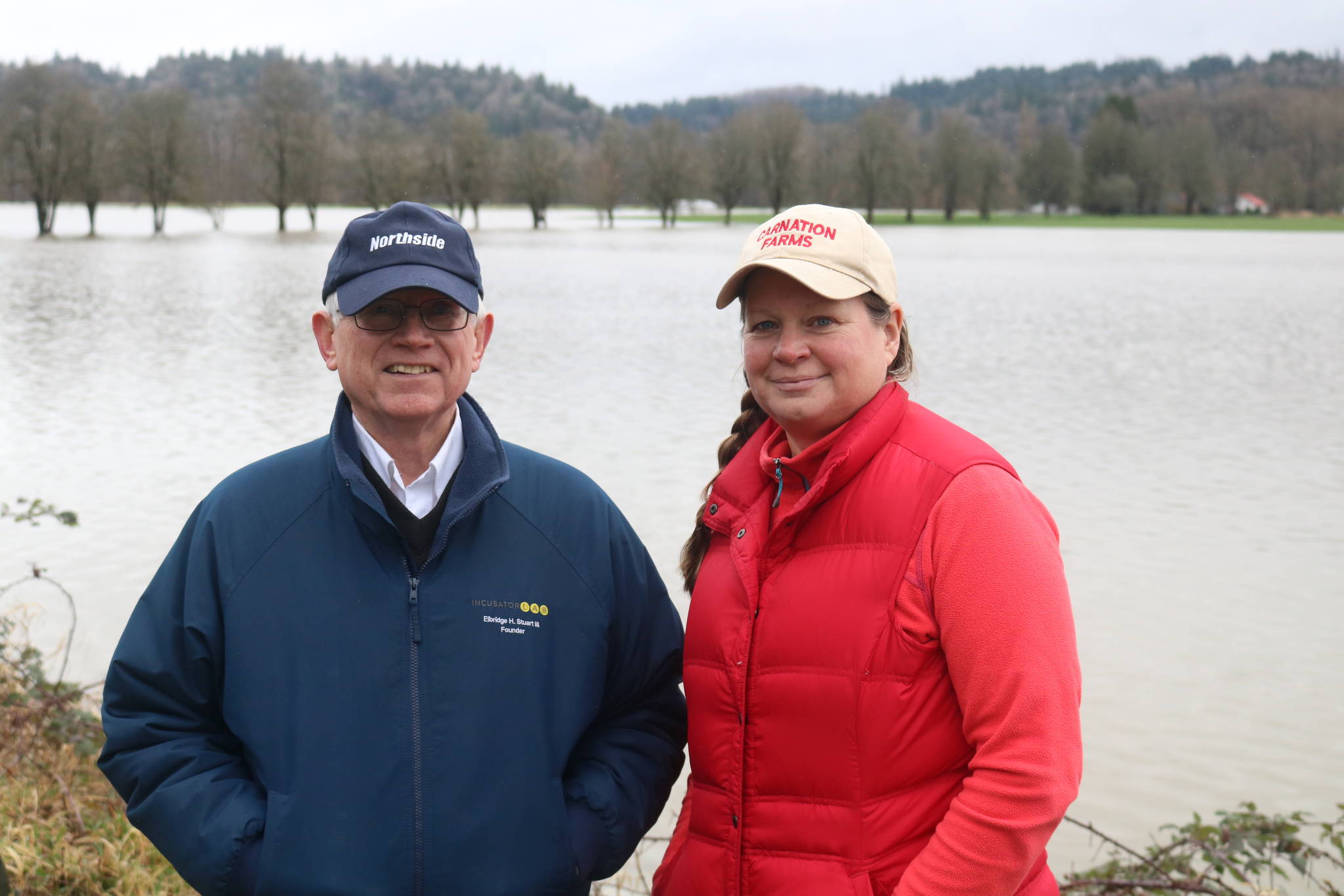 Elbridge Stuart and Rosy Smit stand in front of Carnation Farms’ flooded fields on Feb. 7, 2020. It’s the fifth flood this year along the Snoqualmie River that has broken 56 feet. Aaron Kunkler/staff photo