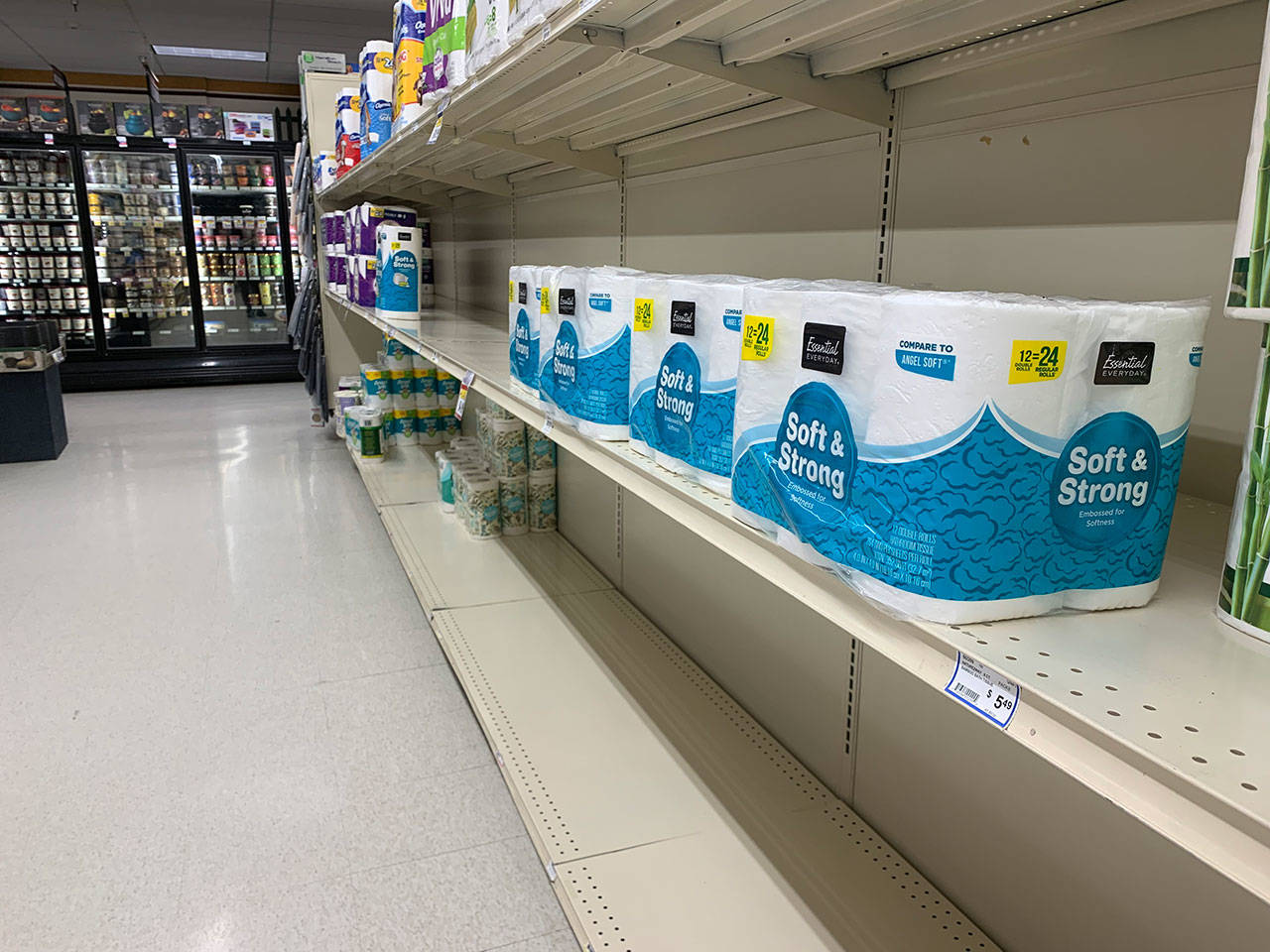 Empty or almost bare shelves in the toilet paper and towel isle of Vashon’s Thriftway are seen on Monday night. (Kevin Opsahl/Staff Photo)