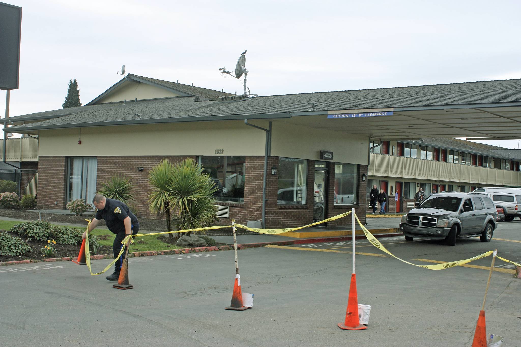 A security guard positions cones as he stands watch in front of the Econo Lodge-turned-coronavirus-quarantine site on Central Avenue North on Tuesday. King County personnel were on site preparing the motel. MARK KLAAS, Kent Reporter