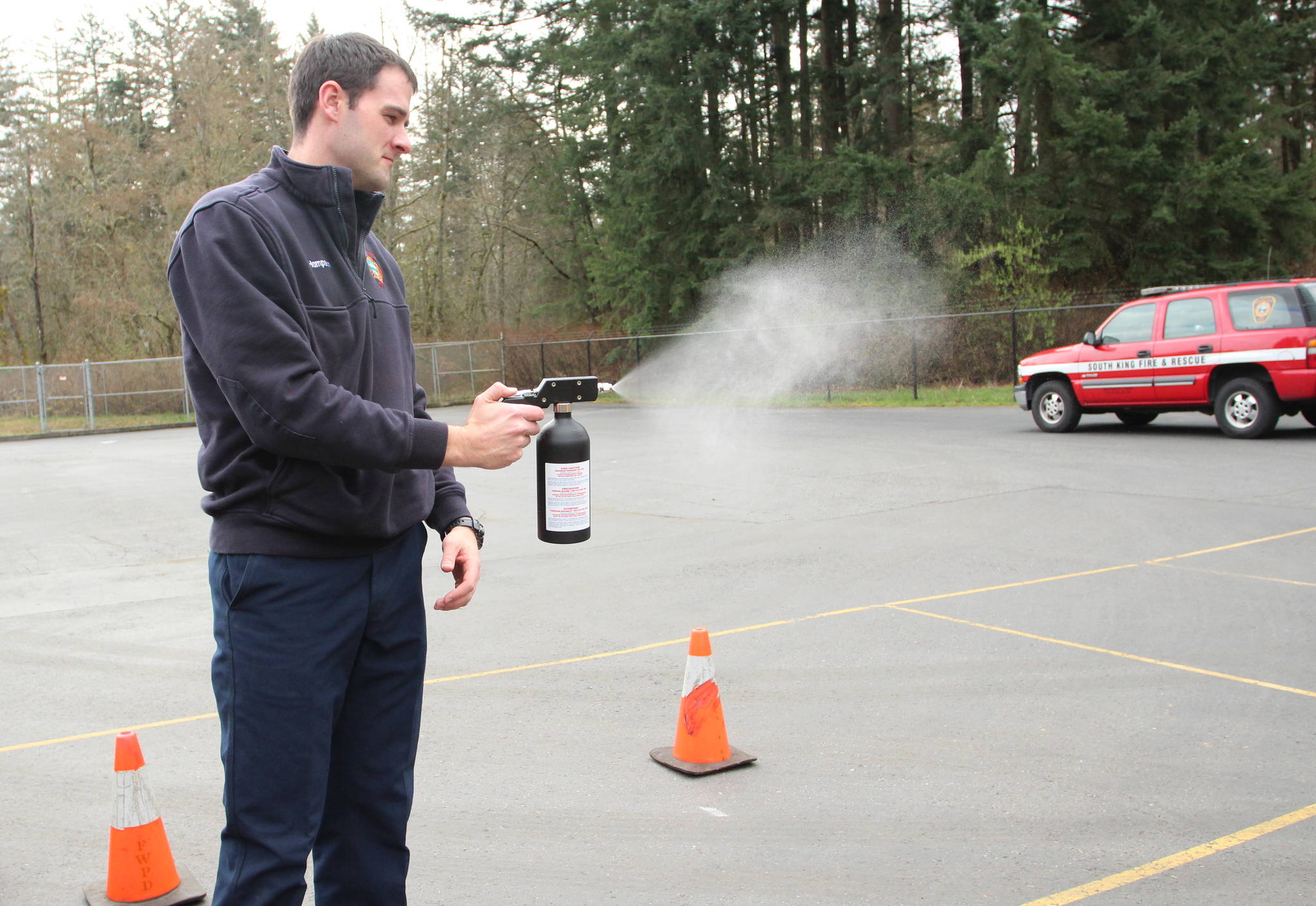 Firefighter James Hampson demonstrates the atomizing sprayer used to disinfect an officer’s weapons, body armor or other equipment. Olivia Sullivan/staff photo