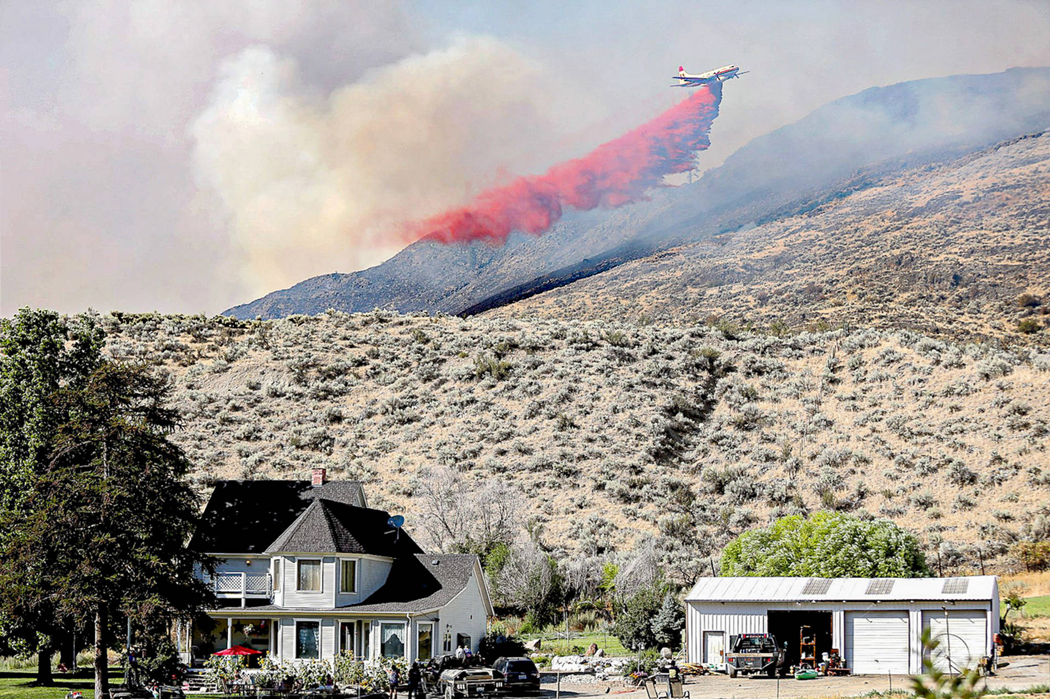 A plane drops fire retardant on the Palmer Mountain Fire last week. The fire is listed as 84 percent contained, and fully lined. Laura Knowlton/Sound Publishing staff photo